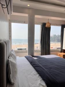 a bedroom with a bed and a view of the beach at Baga beach front in Baga