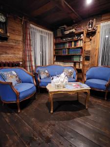 - un salon avec deux chaises bleues et une table basse dans l'établissement Atomi, à Aucugals