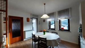 een keuken en eetkamer met een witte tafel en stoelen bij Apartma Mika in Most na Soči