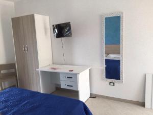 a bedroom with a white desk and a mirror at Red Stone in Diamante