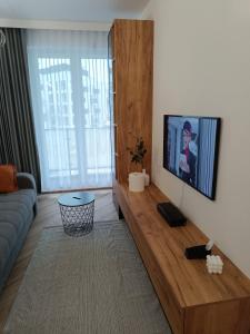 a living room with a couch and a flat screen tv at Amaprament Do Poznania self check-in 24h, free parking in Poznań