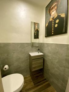 a bathroom with a toilet and a picture of a man at Maison 4 personnes centre-lac in Gérardmer +8 photos