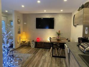a living room with a television on the wall at Maison 4 personnes centre-lac in Gérardmer