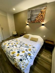 Maison 4 personnes centre-lac في جوراردُميه: غرفة نوم مع سرير مع لحاف متهالك