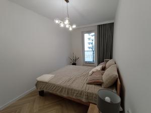 a white bedroom with a bed and a window at Apartament Do Poznania self check-in 24h, free parking in Poznań