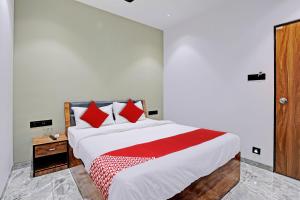 a bedroom with a large white bed with red pillows at OYO Flagship Hotel Laksh View in Surat