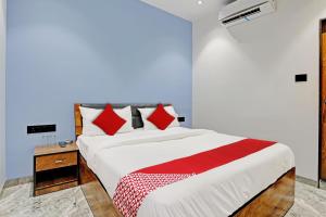 a bedroom with a large bed with red pillows at OYO Flagship Hotel Laksh View in Surat