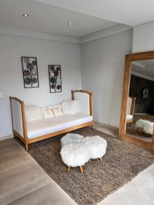 een woonkamer met een witte bank en een spiegel bij Renata 23 in Pinamar