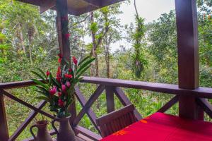 a porch with a table and flowers on it at CASITAS GINGER in Quepos
