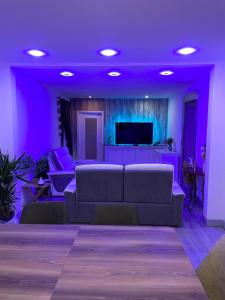 a living room with a couch and purple lighting at la Colombière in Longvic