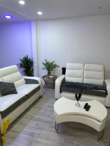 a living room with two couches and a coffee table at la Colombière in Longvic