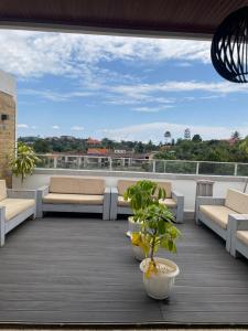 a balcony with couches and plants on a roof at Kantree House - Safari Suites in Kampala