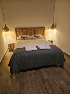 a bedroom with a bed with love pillows on it at El Mirador de Teo in Alocén