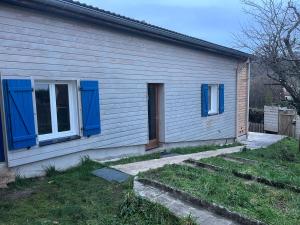 uma casa com persianas azuis ao lado dela em L ermitage Appartement 4 couchages avec terrasse et jardin, à 7 kms de Metz em Lessy