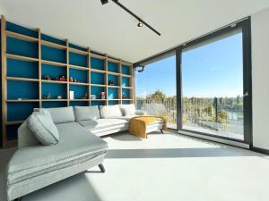 ein Wohnzimmer mit einem Sofa und einem großen Fenster in der Unterkunft Danube Luxury Suite in Budapest