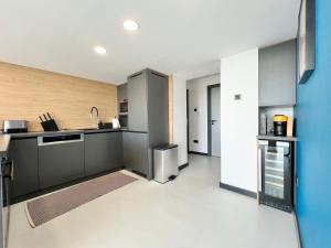 a kitchen with gray cabinets and a blue wall at Danube Luxury Suite in Budapest