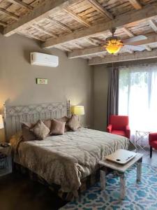 a bedroom with a large bed and a red chair at View Hotel Boutique in San Miguel de Allende