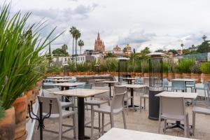 a row of tables and chairs on a patio with plants at Casa 1810 Parque Hotel Boutique in San Miguel de Allende