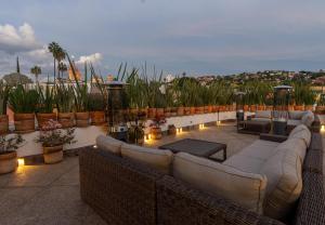 un patio en la azotea con sofás, plantas y luces en Casa 1810 Parque Hotel Boutique en San Miguel de Allende