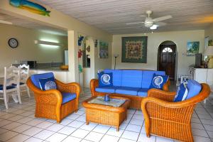 - un salon avec des chaises en osier et un canapé bleu dans l'établissement Admiral's Quay #5 - Comfortable 1-bed Townhouse townhouse, à Rodney Bay Village