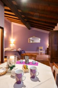 Casina的住宿－Agriturismo di Sordiglio，一间房间,配有一张桌子、两个杯子和一张床