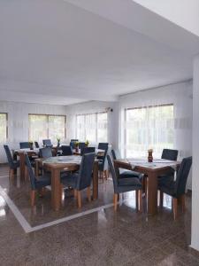 a dining room with wooden tables and chairs at Paradiso Resort in Sarinasuf