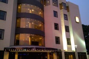 a large building with a balcony in front of it at Hotel Royal Kinshasa in Kinshasa