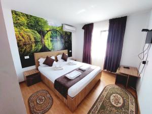 1 dormitorio con 1 cama y una pintura en la pared en Paradiso Resort en Sarinasuf