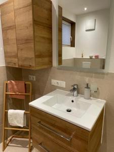 een badkamer met een witte wastafel en een spiegel bij Ferienwohnung Eder in Sankt Jakob in Haus