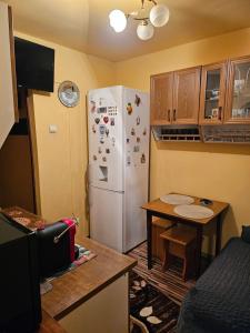 eine Küche mit einem weißen Kühlschrank und einem Tisch in der Unterkunft Cazare Bailesti in Băileşti