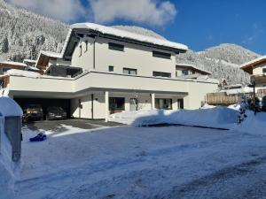 una casa con mucha nieve delante de ella en Ferienwohnung Eder, en Sankt Jakob in Haus