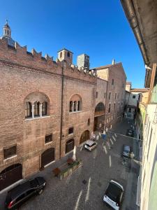 a large brick building with cars parked in front of it at SAN LORENZO Luxury Boutique in Mantova