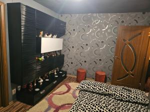 ein Schlafzimmer mit einer schwarzen Wand mit einem Haufen Schuhe in der Unterkunft Cazare Bailesti in Băileşti