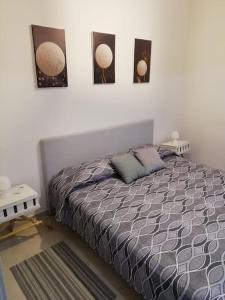 um quarto com uma cama com três fotografias na parede em Casa Sambuco em Volla