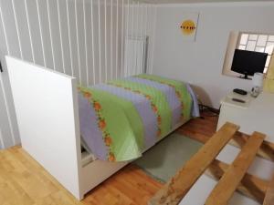 a bedroom with a bed and a desk with a computer monitor at Casa Sambuco in Volla