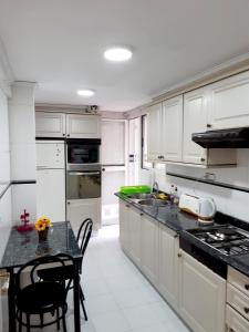 une cuisine avec des placards blancs et un comptoir noir dans l'établissement La Rose, à Gandía