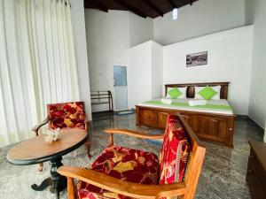 Kandyan View Homestay -For Foreign في كاندي: غرفة نوم بسرير وطاولة وكراسي