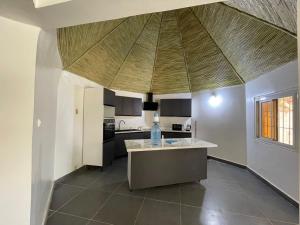 - une cuisine avec un îlot au milieu d'une pièce dans l'établissement ParadisPlage, 1 min de la mer, à Saly Portudal