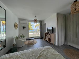 una camera con letto, TV e finestra di ATOUMO vue mer avec cuve a Saint-François