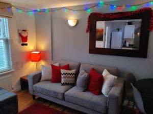 a living room with a couch and a mirror at The Bath House Apartments - Free 1st breakfast - FREE parking in Bath