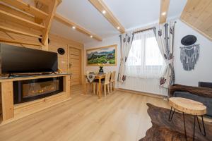 uma sala de estar com uma lareira e uma mesa em Apartamenty Zakopiańska Polana em Zakopane