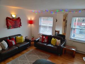 uma sala de estar com dois sofás de couro preto em The Bath House Apartments - Free 1st breakfast - FREE parking em Bath