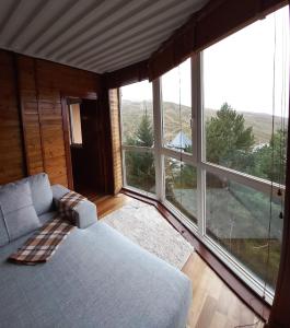 a living room with a couch and large windows at Bed and Snow Ski in Sierra Nevada