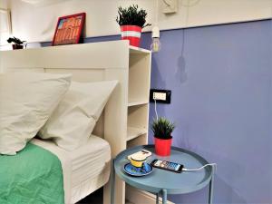 um quarto com uma cama e uma mesa com controlo remoto em Central Apartments®Borgo Street 1 min to Via Etnea em Catânia
