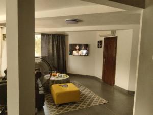 ein Wohnzimmer mit einer gelben Ottomane in der Mitte in der Unterkunft ParadisPlage, 1 min de la mer in Saly Portudal