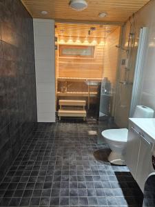 a bathroom with a tub and a toilet and a sink at Sauna and the City in Rovaniemi