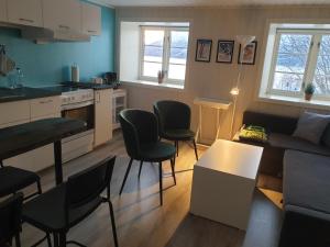 een keuken en een woonkamer met een bank en stoelen bij Olderdalen Ski Camp in Olderdalen