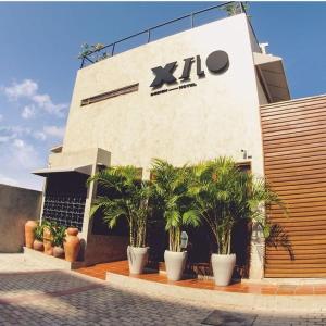 a building with palm trees in front of it at Xilo Design Hotel in João Pessoa