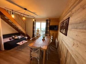 uma sala de estar com uma mesa de madeira e um quarto em T3 duplex Super Besse, parking, piscine, wifi em Besse-et-Saint-Anastaise