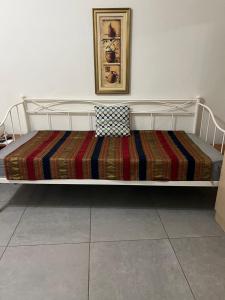 a bed with a striped blanket on top of it at Centrally Located Private Rooms in Heraklio Town